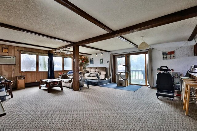 203 S Main St, Deerfield, WI 53531 - carpeted living room with beamed ceiling, a wall mounted air conditioner, a textured ceiling, and wood walls