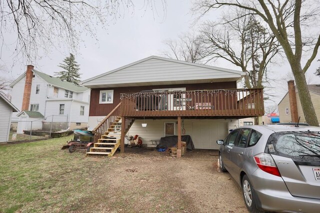 203 S Main St, Deerfield, WI 53531 - back of house featuring driveway, fence, a garage, a wooden deck, and stairs