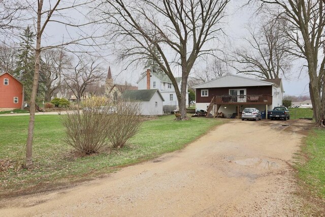203 S Main St, Deerfield, WI 53531 - view of front of property featuring a wooden deck, stairs, driveway, and a front yard