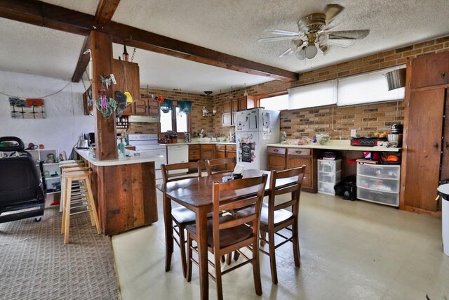 203 S Main St, Deerfield, WI 53531 - dining space featuring beam ceiling, brick wall, a ceiling fan, and a textured ceiling