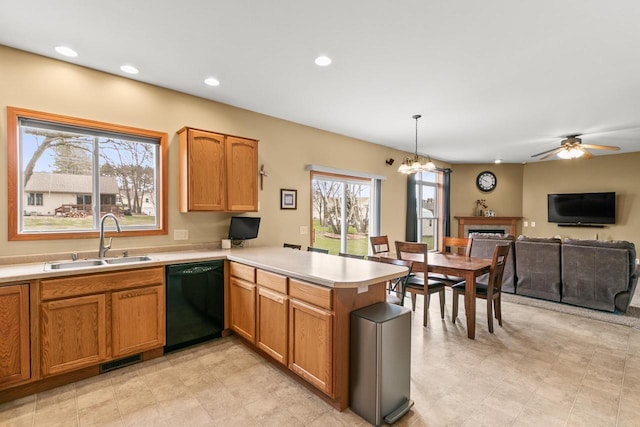 kitchen with a peninsula, light countertops, a sink, visible vents, and dishwasher