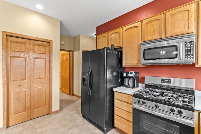 kitchen featuring baseboards, stainless steel appliances, and light countertops