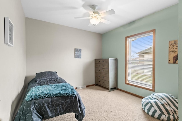 carpeted bedroom with baseboards, a ceiling fan, and visible vents