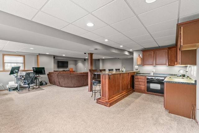 kitchen featuring light carpet, oven, and a drop ceiling