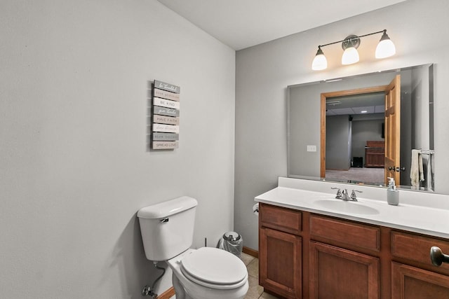 half bathroom with toilet, vanity, and baseboards