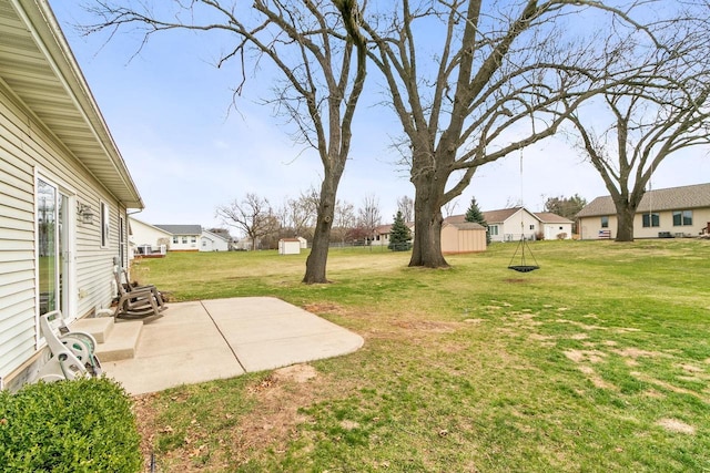 view of yard with a storage shed, a residential view, a patio area, and an outbuilding