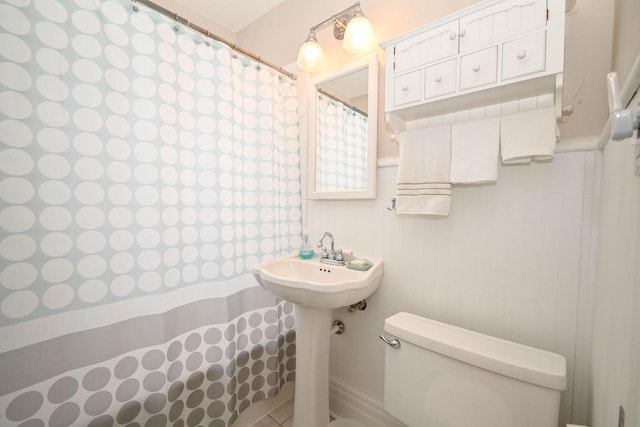 bathroom with toilet and a shower with curtain