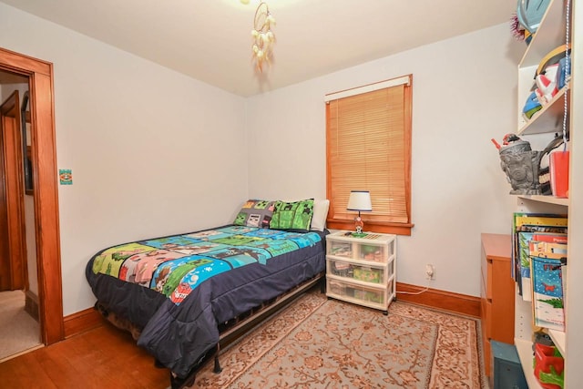 bedroom featuring baseboards and wood finished floors