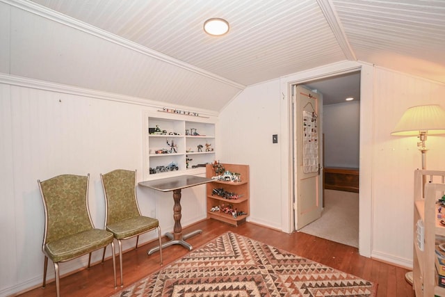 living area with lofted ceiling, built in shelves, and wood finished floors