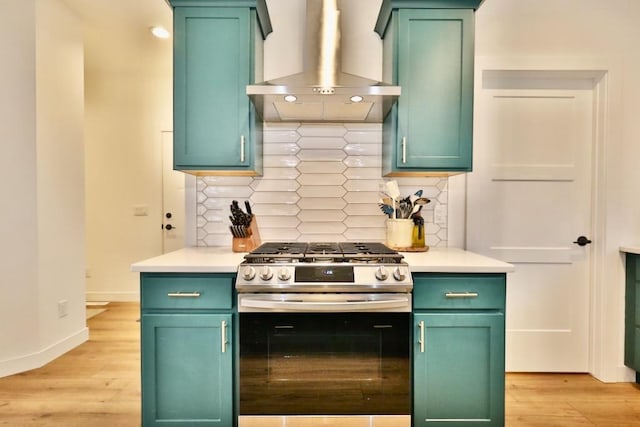 kitchen with light countertops, light wood-type flooring, stainless steel range with gas stovetop, and exhaust hood