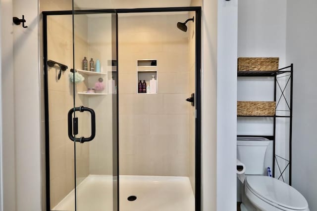 full bathroom featuring a shower stall and toilet