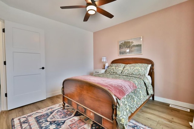 bedroom featuring ceiling fan, baseboards, wood finished floors, and visible vents