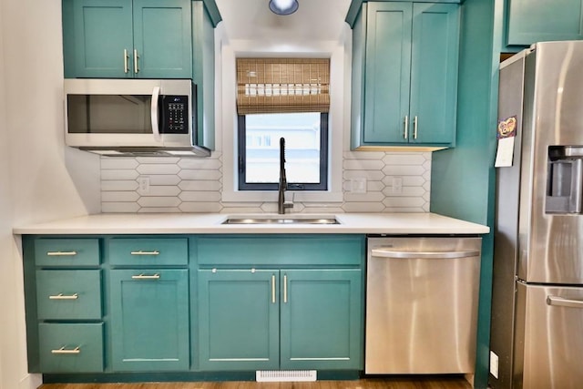 kitchen with light countertops, stainless steel appliances, visible vents, and a sink