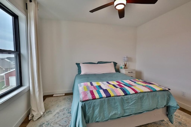 bedroom with wood finished floors, a ceiling fan, and baseboards
