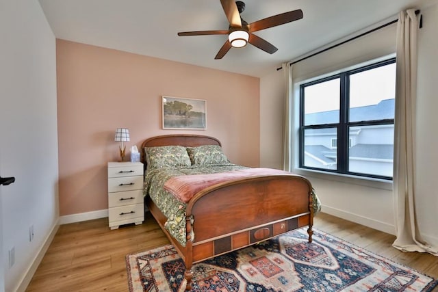 bedroom with wood finished floors, baseboards, and ceiling fan