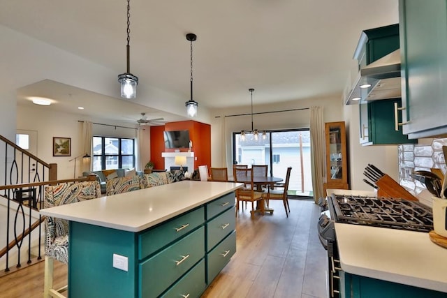 kitchen featuring gas range oven, green cabinetry, a kitchen island, and light countertops