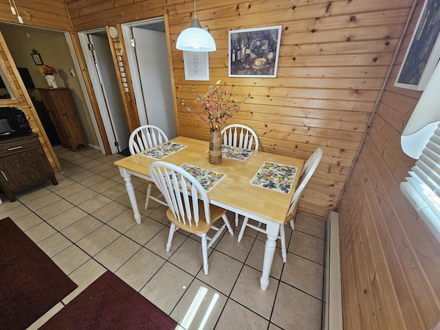 dining space with wood walls and light tile patterned floors