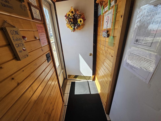 doorway to outside with wood walls