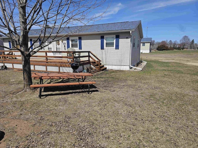 back of house featuring a wooden deck and a shingled roof