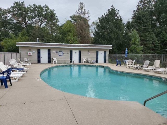 pool featuring fence and a patio