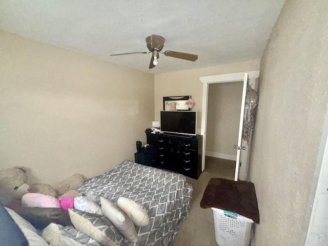 bedroom featuring a textured wall and ceiling fan