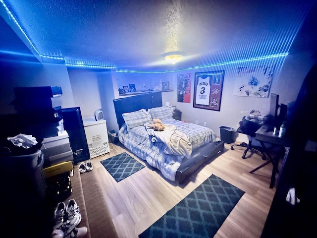bedroom featuring wood finished floors and a textured ceiling