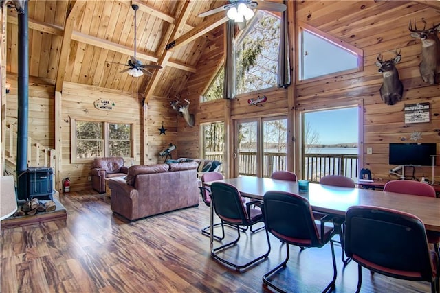 5044 Clayton Rd, Winter, WI 54896 - dining area featuring high vaulted ceiling, ceiling fan, wood walls, and a wood stove