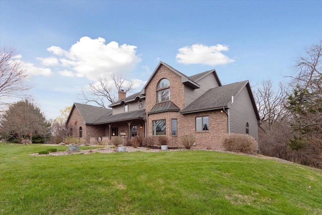 2555 W Deer Path Trl, Janesville, WI 53545 - view of front of property featuring roof with shingles, a front lawn, a chimney, covered porch, and brick siding