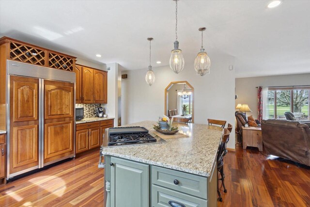 2555 W Deer Path Trl, Janesville, WI 53545 - kitchen featuring a center island, open floor plan, backsplash, built in appliances, and wood finished floors