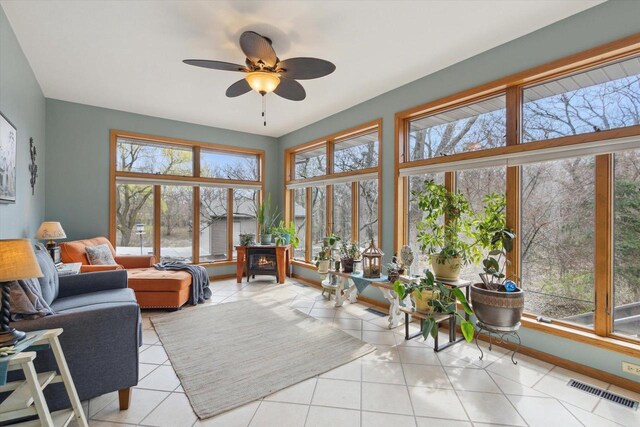 2555 W Deer Path Trl, Janesville, WI 53545 - sunroom featuring tile patterned floors, baseboards, visible vents, and a wood stove