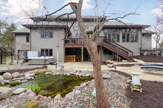 2555 W Deer Path Trl, Janesville, WI 53545 - back of property featuring stairway, a patio area, a deck, fence, and a hot tub