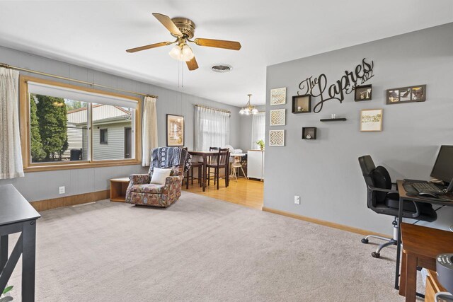 office area with carpet flooring, a ceiling fan, visible vents, and plenty of natural light