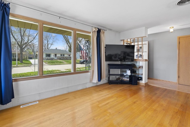 unfurnished living room with visible vents and wood finished floors