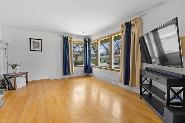 unfurnished living room with baseboards and wood finished floors