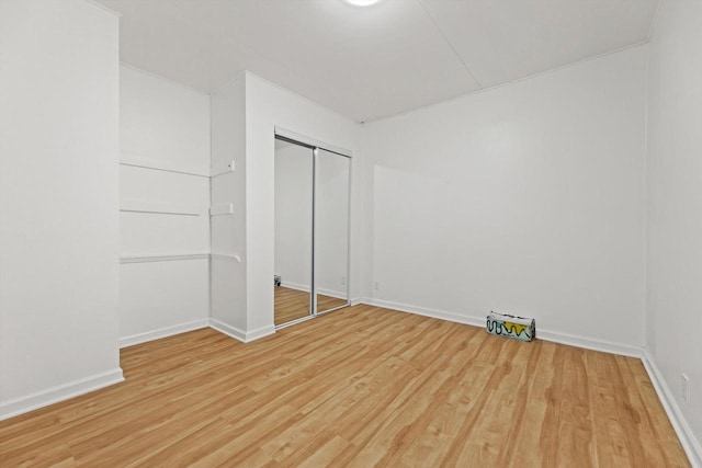 W160N9696 Colonial Dr, Germantown, WI 53022 - unfurnished bedroom with light wood-style flooring, a closet, and baseboards