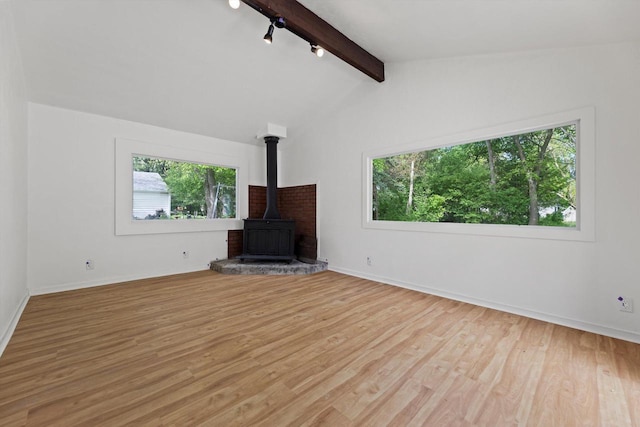 W160N9696 Colonial Dr, Germantown, WI 53022 - unfurnished living room featuring a wood stove, wood finished floors, baseboards, and track lighting
