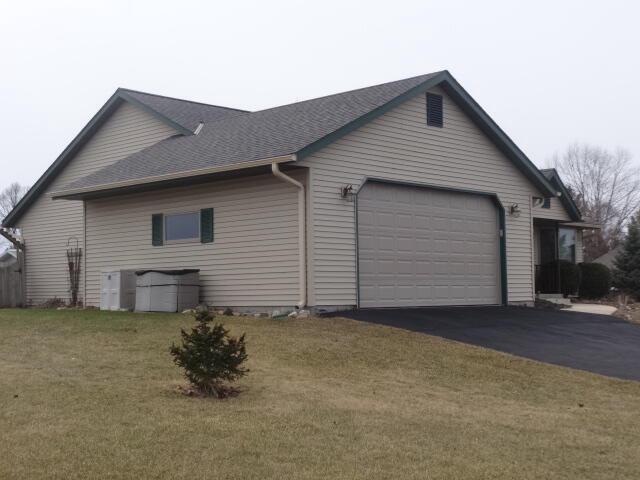 545 Skyhawk Ave, Campbellsport, WI 53010 - view of side of property featuring a yard, an attached garage, driveway, and roof with shingles