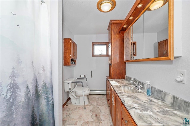 W7604 Sleepy Eye Rd, Minong, WI 54859 - full bath featuring a baseboard heating unit, vanity, marble finish floor, baseboards, and toilet