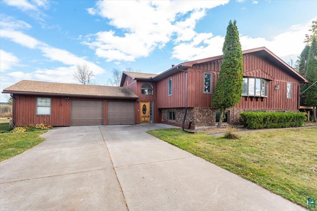 2608 Logan Ave, Superior, WI 54880 - view of front of property with board and batten siding, a front lawn, and a garage