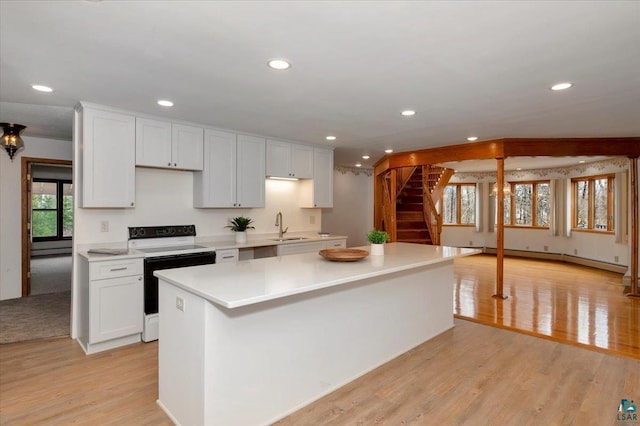 2608 Logan Ave, Superior, WI 54880 - kitchen featuring a baseboard radiator, a sink, light countertops, electric range, and recessed lighting