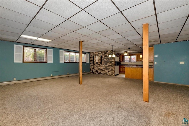 2608 Logan Ave, Superior, WI 54880 - below grade area featuring a baseboard heating unit, light carpet, a paneled ceiling, and baseboards