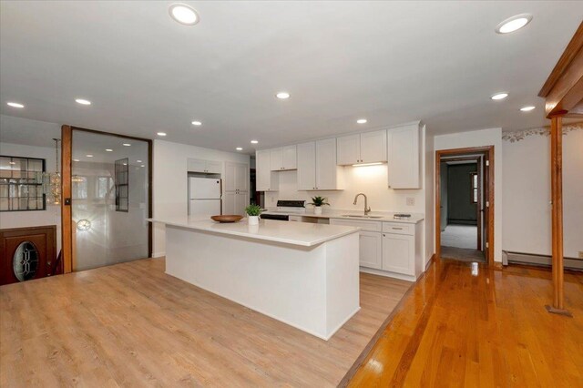 2608 Logan Ave, Superior, WI 54880 - kitchen featuring a sink, freestanding refrigerator, light countertops, white cabinets, and recessed lighting