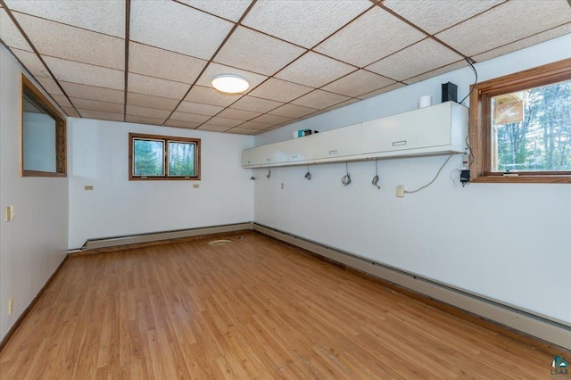 2608 Logan Ave, Superior, WI 54880 - below grade area with a baseboard heating unit, light wood-style flooring, baseboard heating, and plenty of natural light
