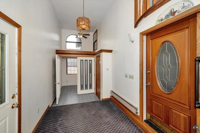 2608 Logan Ave, Superior, WI 54880 - entrance foyer with baseboards, a notable chandelier, dark tile patterned flooring, high vaulted ceiling, and a baseboard radiator