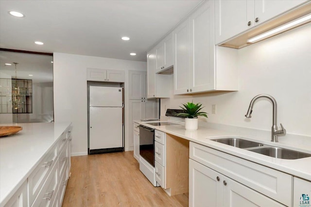 2608 Logan Ave, Superior, WI 54880 - kitchen featuring a sink, light wood-type flooring, freestanding refrigerator, light countertops, and recessed lighting