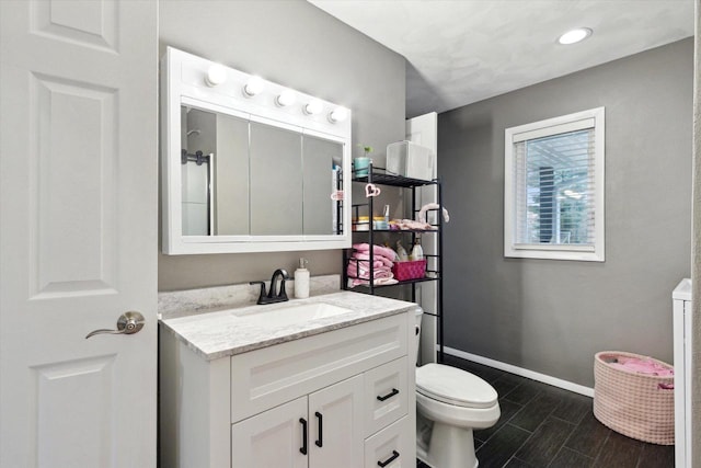 4441 N John Paul Rd, Milton, WI 53546 - bathroom featuring recessed lighting, toilet, vanity, baseboards, and wood finish floors