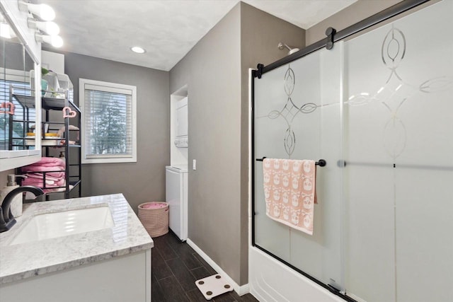 4441 N John Paul Rd, Milton, WI 53546 - bathroom with shower / bath combination with glass door, stacked washer / drying machine, recessed lighting, vanity, and baseboards