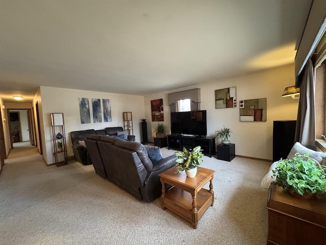 living area featuring baseboards and light carpet