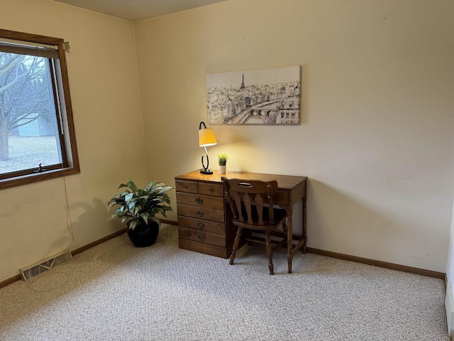 office area with visible vents, baseboards, and light carpet