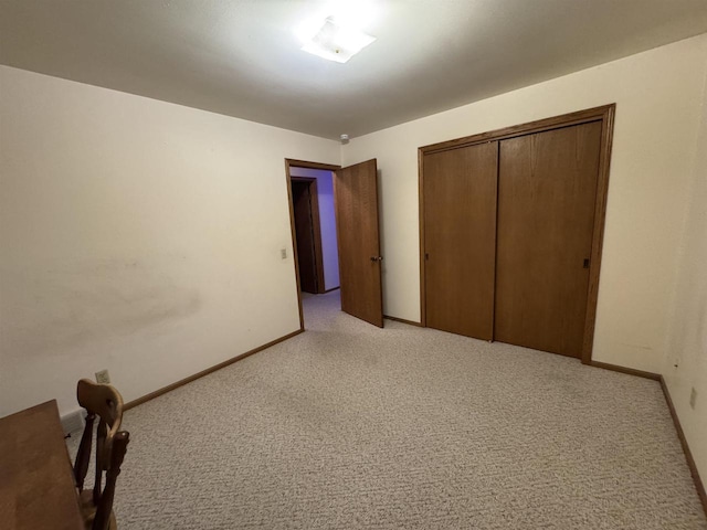 unfurnished bedroom featuring light carpet and baseboards